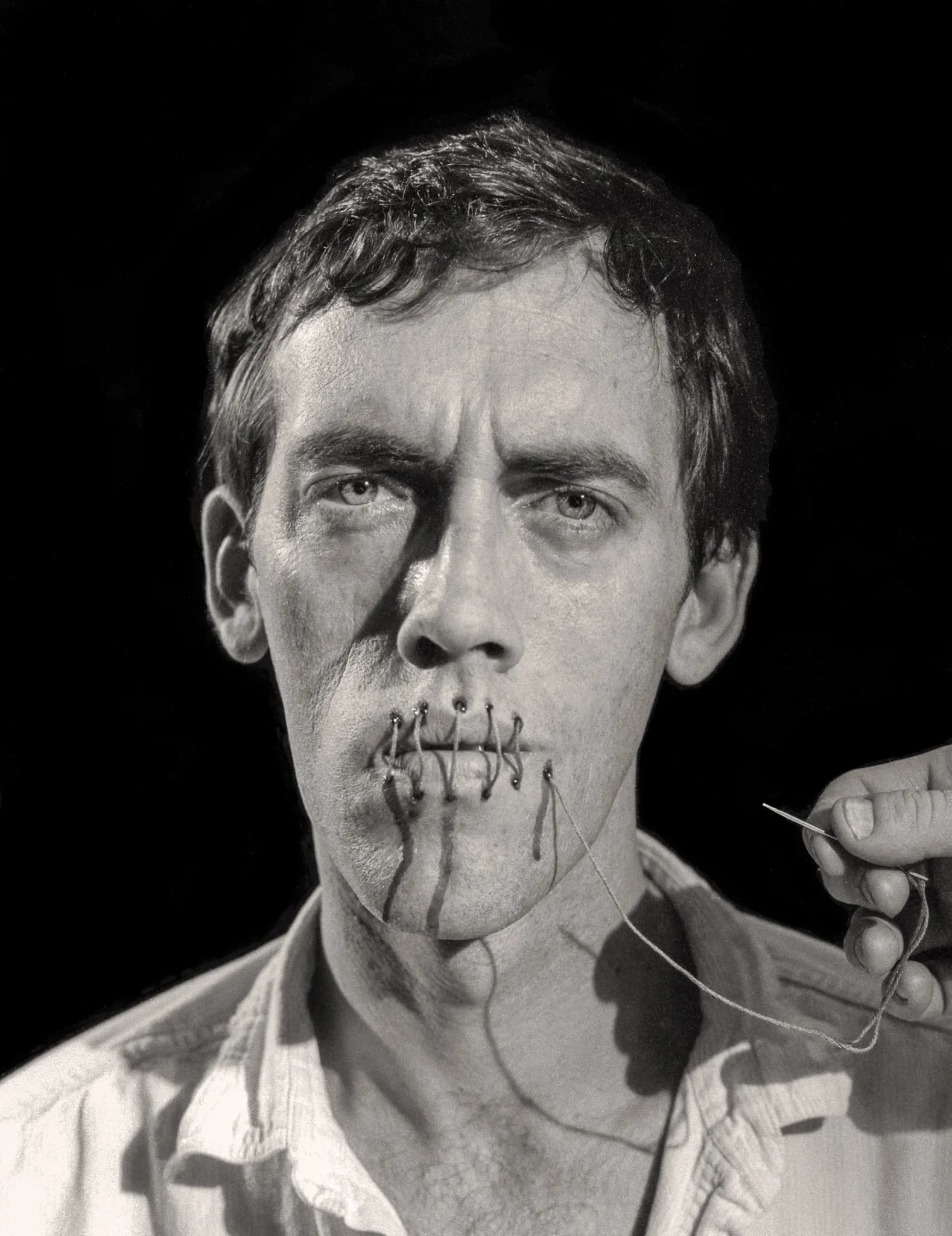 David Wojnarowicz in front of his striking artwork, expressing themes of AIDS and activism.