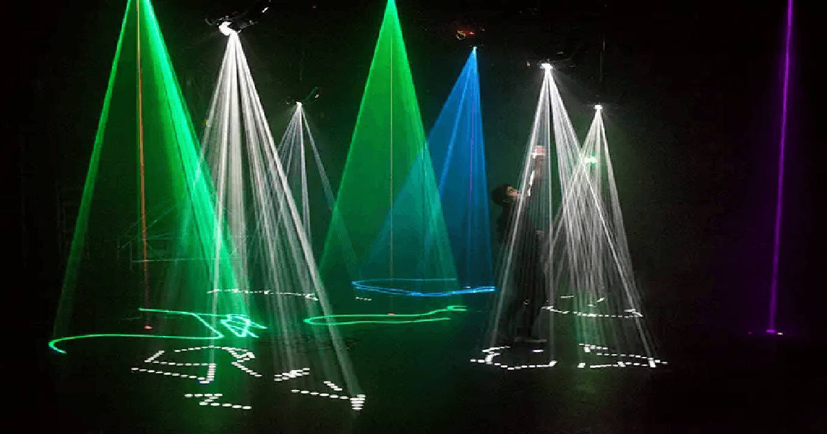 A person observing a light display generated by a machine at an art and technology exhibit.